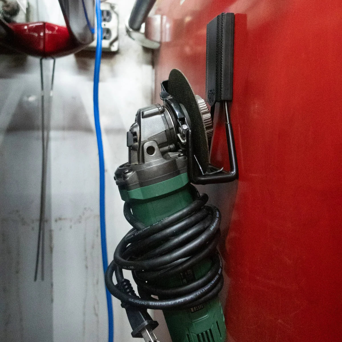 Gator Magnetics The Pro Tradie 8 Bundle — green angle grinder and coiled cord on a black hook against red steel